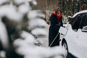 Femme rechargeant sa voiture électrique dans la neige.jpg
